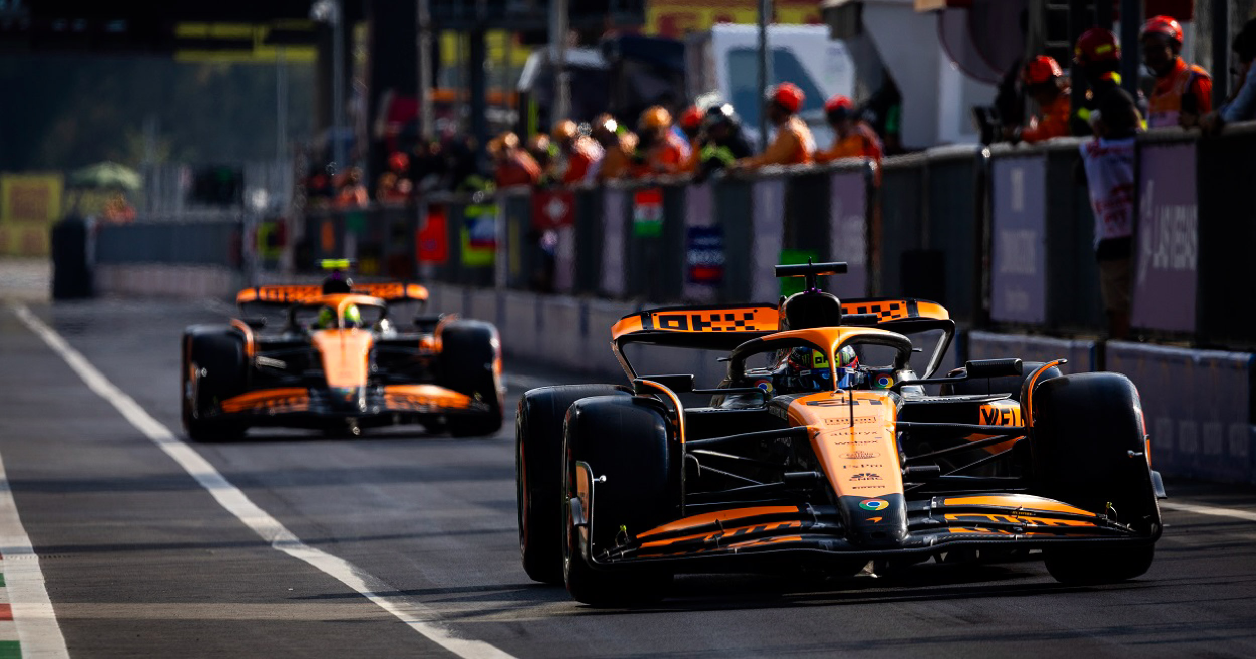 McLaren Formula 1 cars entering the pit lane during the 2024 Azerbaijan Grand Prix at Baku City Circuit