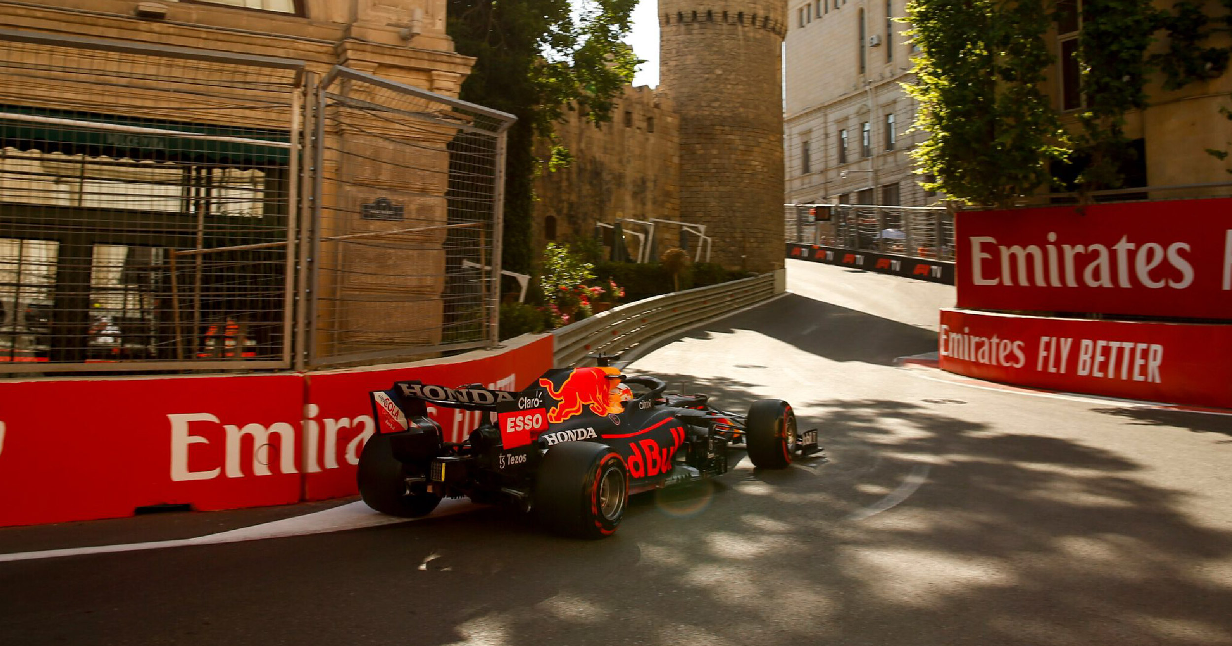 Red Bull Racing Formula 1 car navigating a tight corner near the historic walls of Baku during the 2024 Azerbaijan Grand Prix.