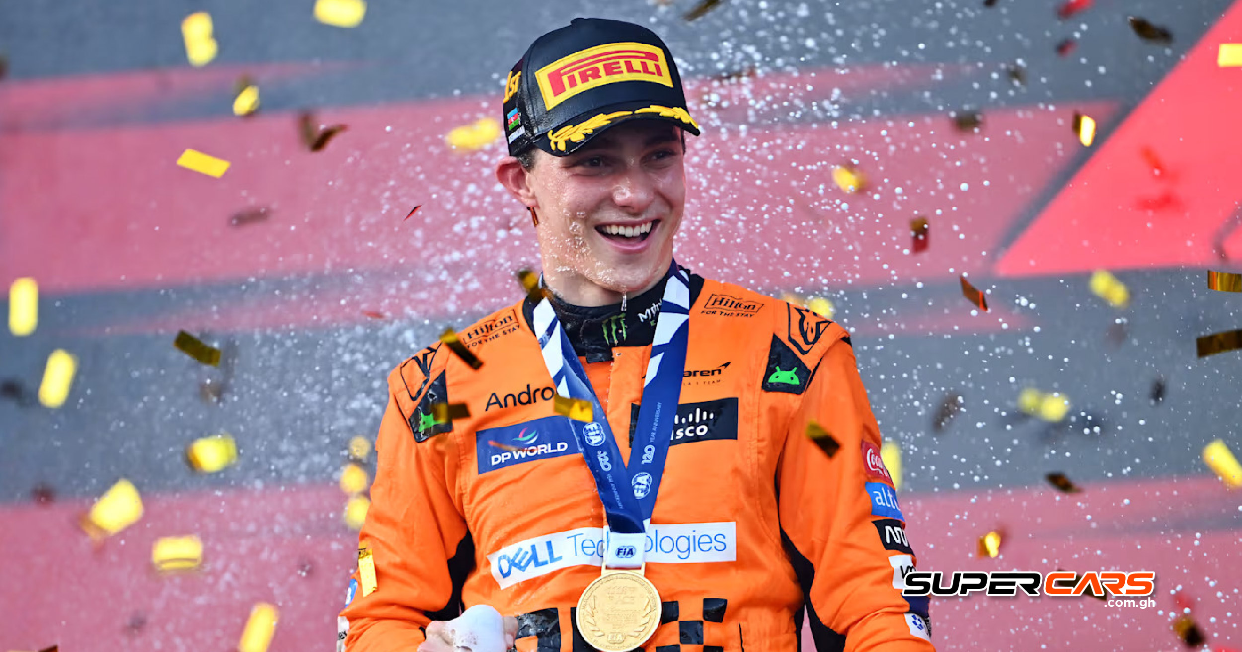 Oscar Piastri of McLaren celebrates on the podium after winning at the 2024 Azerbaijan Grand Prix, showered in confetti and holding his winner’s medal.