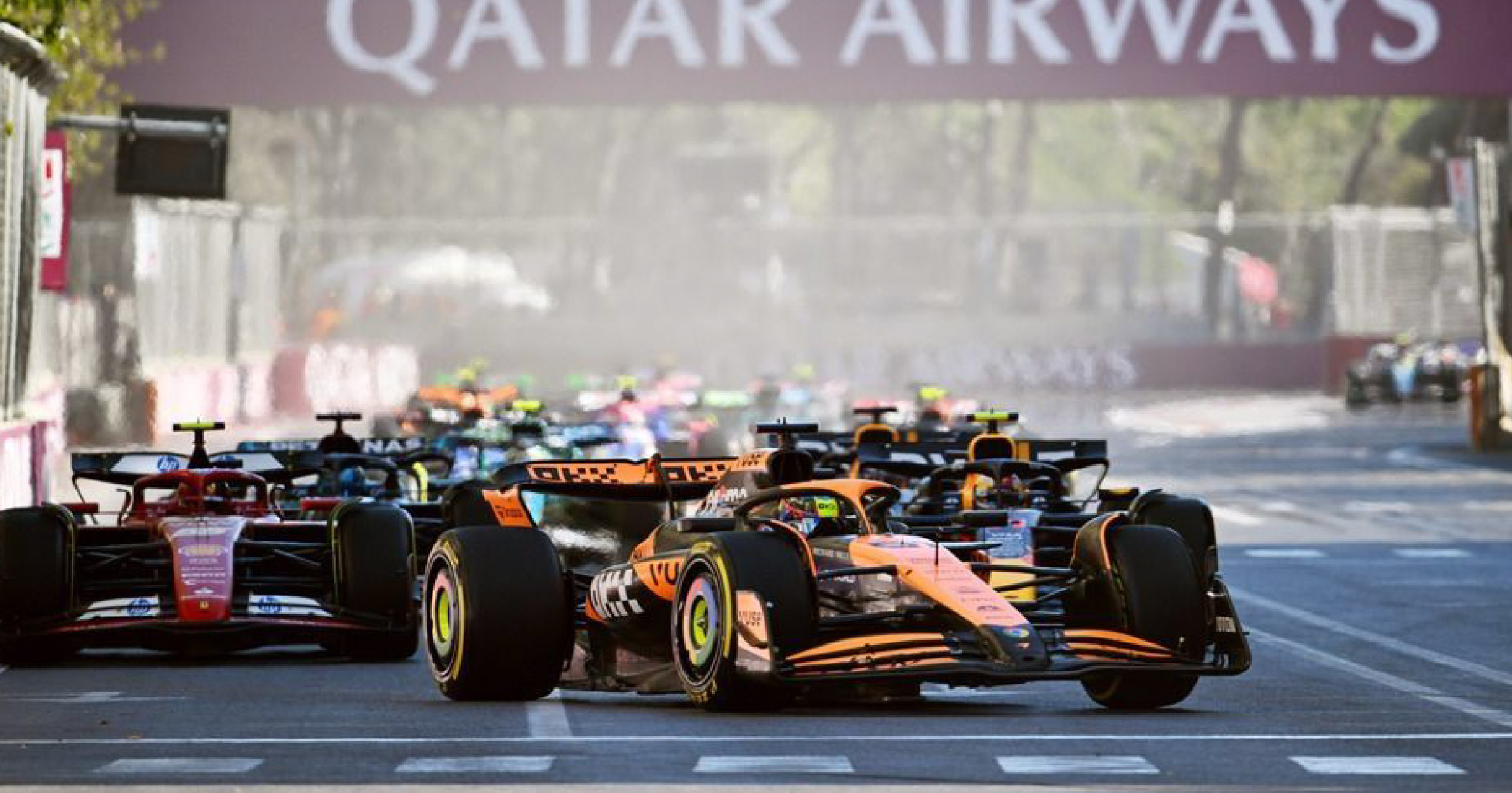 McLaren and Ferrari Formula 1 cars leading the pack during the 2024 Azerbaijan Grand Prix, racing through the streets of Baku.