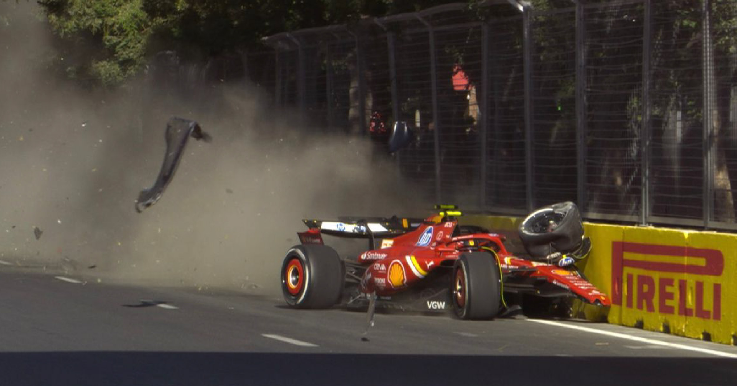 Ferrari Formula 1 car crashes into the barriers during the 2024 Azerbaijan Grand Prix, with debris flying and the car heavily damaged."