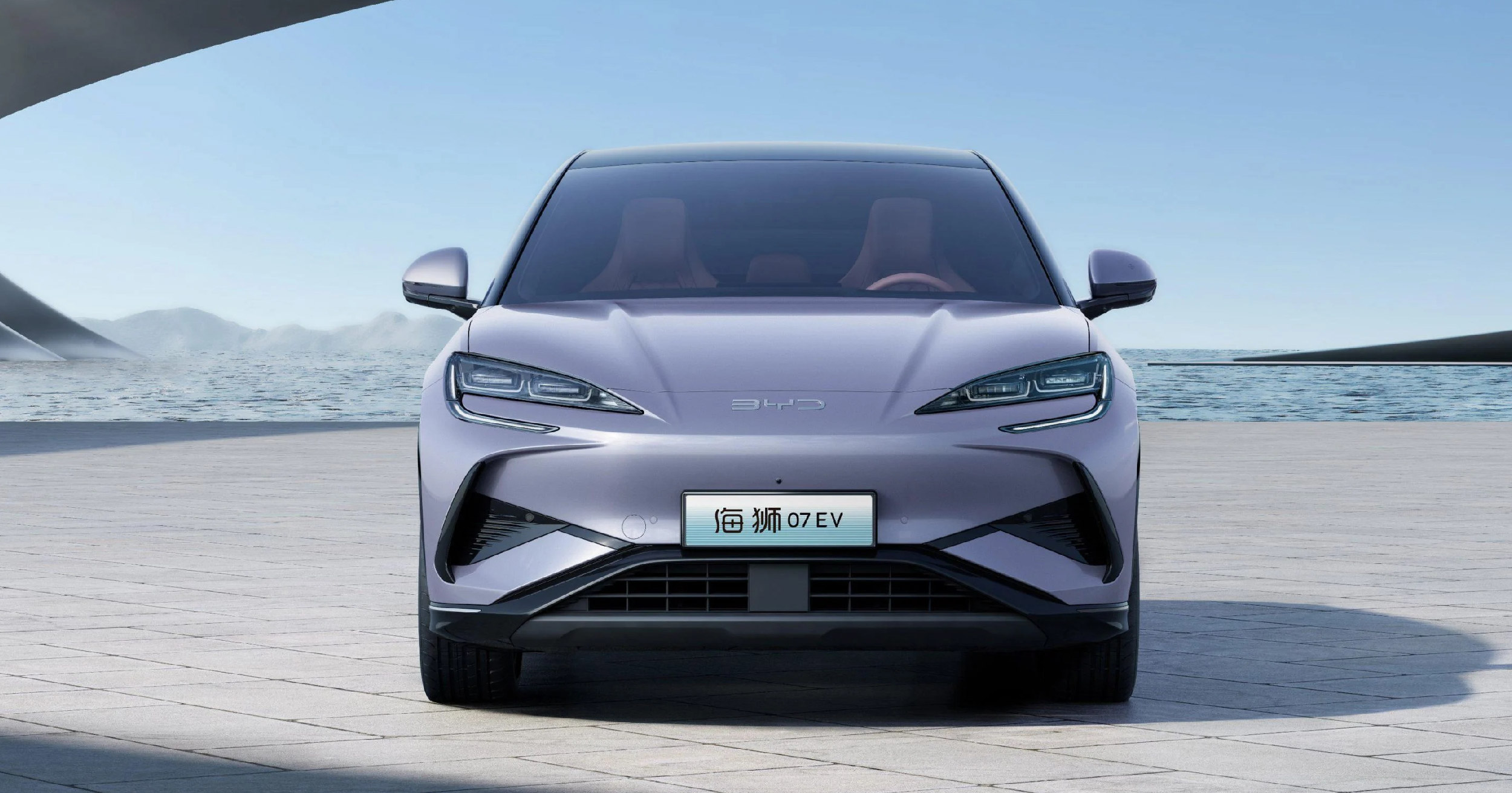 Front view of the sleek BYD Sealion 07 EV in a futuristic coastal setting